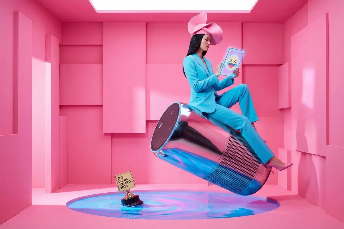 Vrouw in turquoise pak op gigantische blikje in roze ruimte, kijkt naar tablet met lachend emoji